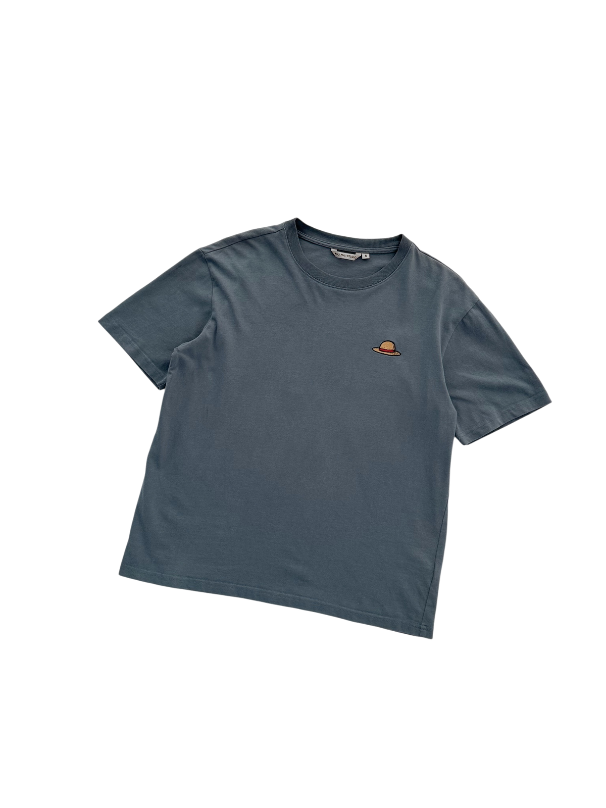 A blue-grey short-sleeve t-shirt with a small orange of a strawhatt, displayed on a clean white background.